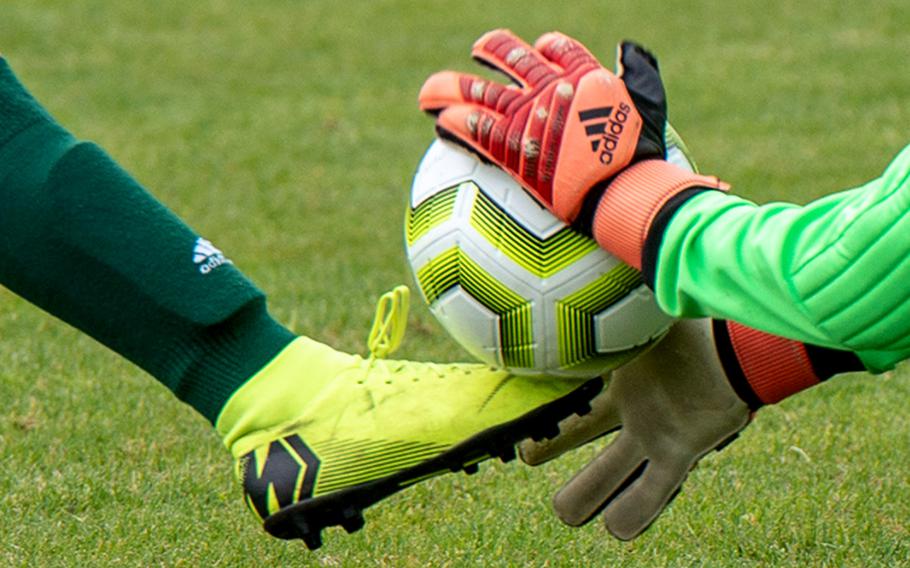 The keeper and an attacker arrive at the ball at the same time.